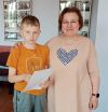 Dziecko pozuje do zdjęcia z instruktorką i dyplomem